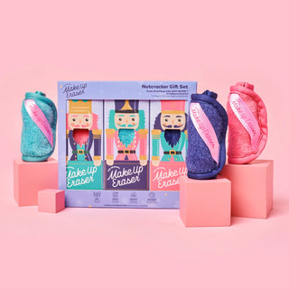 A MakeUp Eraser Nutcracker Gift Set .The set includes a central illustrated gift box showing three nutcracker figures and three physical erasers in teal, navy blue, and pink, each with a strap labeled 'MakeUp Erase'.