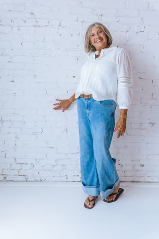 Woman wearing a white blouse and blue jeans 