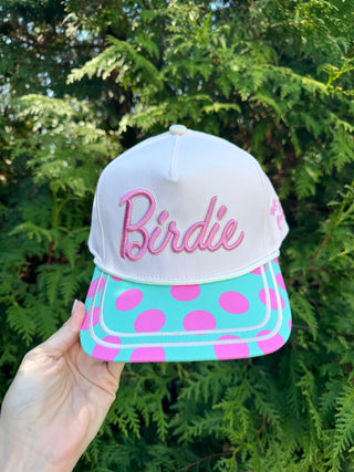 White cap with pink 'Birdie' text and turquoise base with pink polka dots 