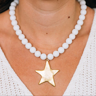 White beaded necklace with a gold star pendant