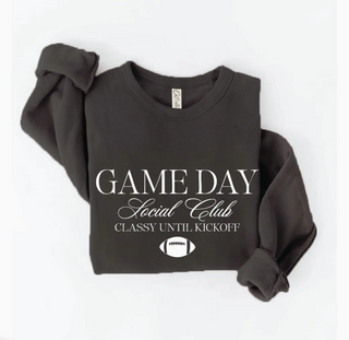 A dark charcoal gray sweatshirt featuring a white graphic print that reads 'GAME DAY Social Club CLASSY UNTIL KICKOFF' with a football icon