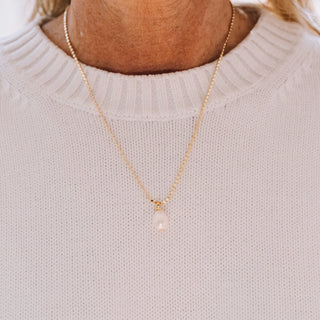 GOLD CHAIN HOLDING TEARDROP PEARL PENDANT 