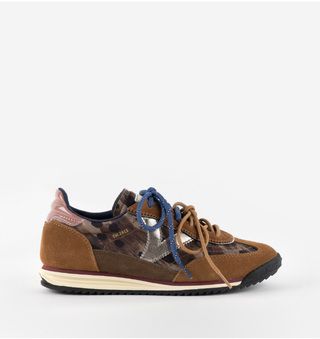 A single low-top sneaker WITH A mix of brown suede, a brown camouflage pattern panel, a metallic silver panel, and blue laces.